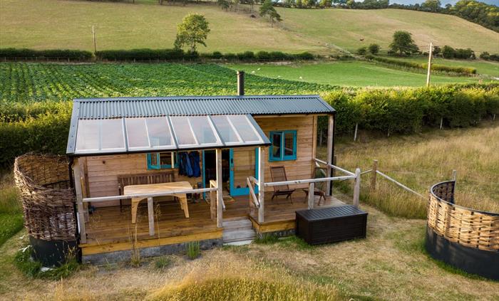 Handbuilt cabin with outdoor bath, set in an enchanting meadow, edge of the historic village of Llanfihangel y Creuddyn in Wales.